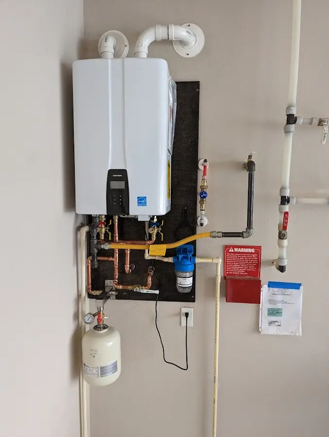 Professional plumber installing copper piping in a Minster home